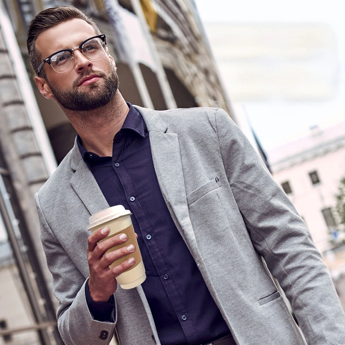 Young man holding a 12 oz eco-friendly hot cup, emphasizing sustainable design.