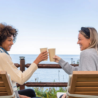 Two women sitting at a table with 16oz Disposable Coffee Cups