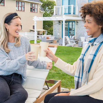 Two women sitting at a table with 12oz Disposable Coffee Cups